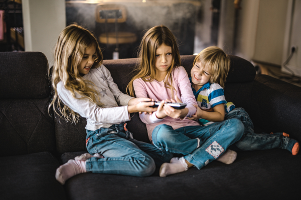 Image: Two girls and one boy fighting over the remote 