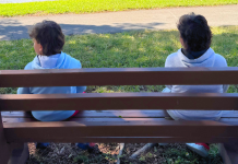 Image: Two children sitting on a park bench