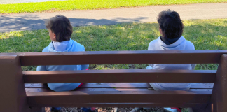 Image: Two children sitting on a park bench