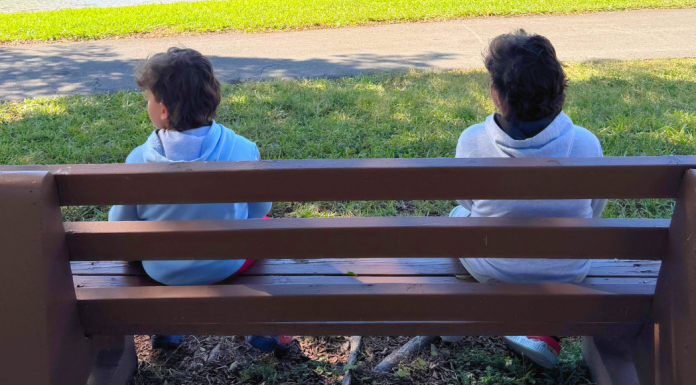 Image: Two children sitting on a park bench