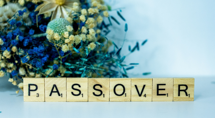 Image: A bouquet of blue dried flowers behind Scrabble tiles spelling out PASSOVER