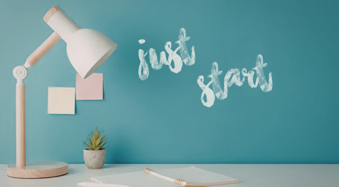 Building a Business with Clarity, Standards, and Scale Image: A desk with a wooden desk lamp and the words "Just Start" written on a wall in the background