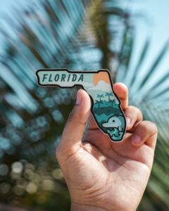 Image: A hand holding a Florida magnet