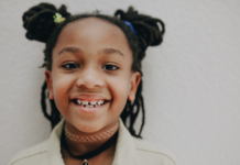 Image: An elementary aged child with pigtails smiles for the camera