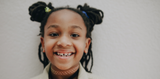 Image: An elementary aged child with pigtails smiles for the camera