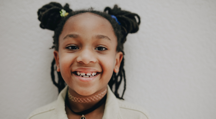Image: An elementary aged child with pigtails smiles for the camera