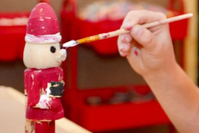Image: A child paints a Santa figure at Elf Factory