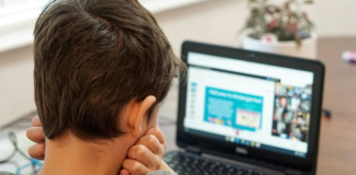 Image: A young boy uses a device for schoolwork