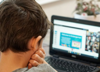 Image: A young boy uses a device for schoolwork