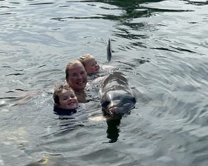 Image: Cierra and her children enjoy a swim with a dolphin at Theater of the Sea in Islamorada