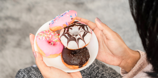 Image: A woman holding a plate of donuts