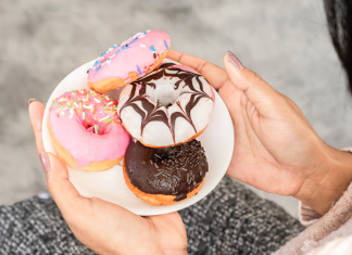 Image: A woman holding a plate of donuts
