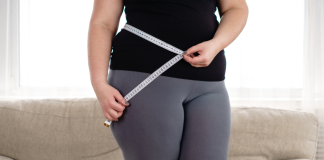 Image: A woman measures her waist