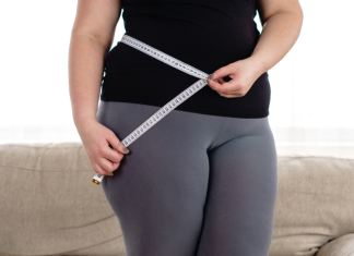 Image: A woman measures her waist