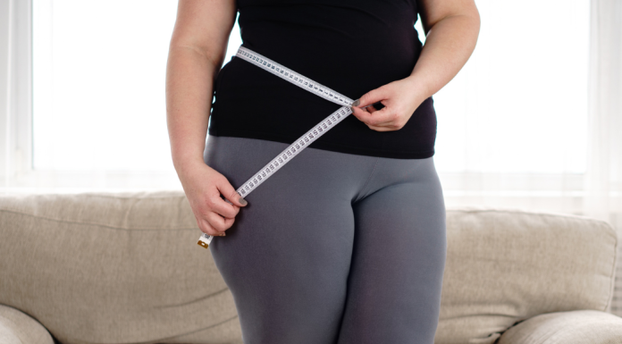 Image: A woman measures her waist