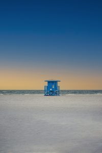 Image: A blue lifeguard stand on Siesta Key Beach at sunset