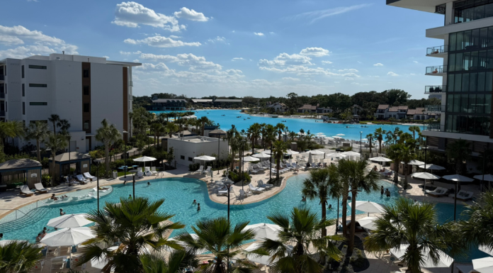 Conrad Orlando: A Family-Friendly Relaxation + Wellness Retreat Image: A balcony view of the pool and lagoon at Conrad Orlando