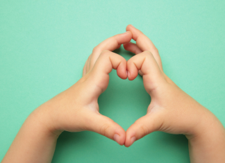 Heart Health Month for Kids: Little Hearts, Big Bites Image: A child makes a heart with their hands