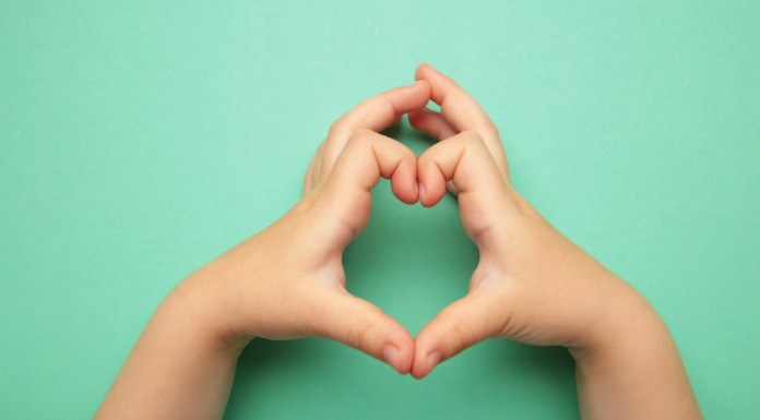 Heart Health Month for Kids: Little Hearts, Big Bites Image: A child makes a heart with their hands