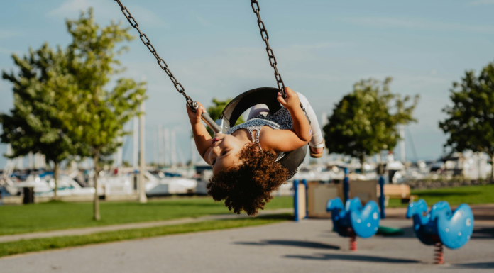 Winter Break in Miami: A Bucket List & To Do List for Miami Moms Image: A little girl in a toddler swing at a playground