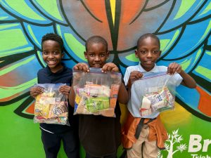 Image: Three children display their holiday snack packs