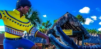 Image: A sculpture depicting a Miccosukee man with an alligator at the entrance to the Miccosukee Indian Village