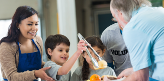Volunteering as a Family: A Meaningful Holiday Tradition Image: A family serves a meal together