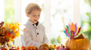Image: A little boy decorates a Thanksgiving table