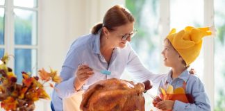 Image: A grandmother bastes a Thanksgiving turkey with a grandchild