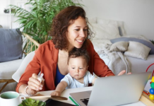 Image: A mother works from home with her toddler in her lap
