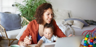 Image: A mother works from home with her toddler in her lap