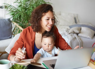 Image: A mother works from home with her toddler in her lap