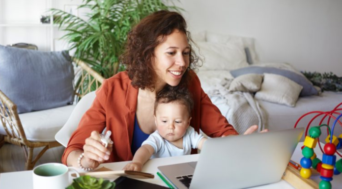 Image: A mother works from home with her toddler in her lap