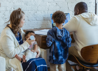 Image: A family sits together and talks about what they see on a computer screen