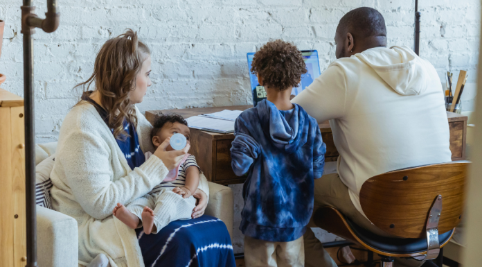 Image: A family sits together and talks about what they see on a computer screen
