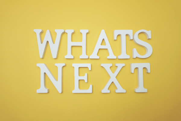 Image: White letters on a yellow background that read, Whats Next
