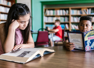 Library Card Sign-Up Month: So Much to Check Out Image: Children read books at a local library