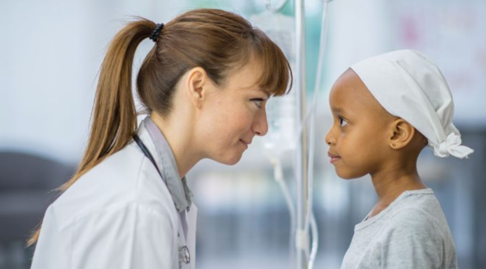 Image: A doctor kneels down to eye level with a pediatric patient