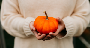 Image: A child holding a small pumpkin