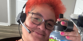 Image: Natasha Arias sits at her desk with a headset, ready for work