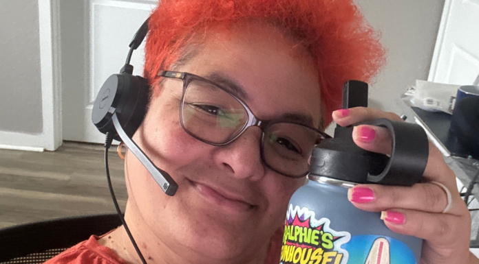 Image: Natasha Arias sits at her desk with a headset, ready for work