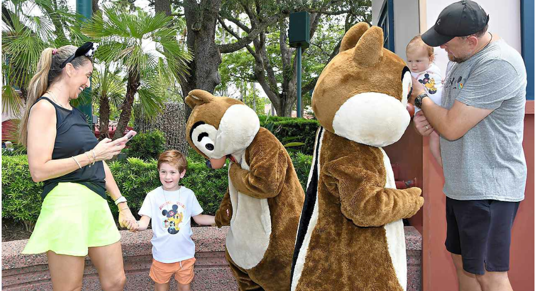 Image: Sandra with her husband and kids enjoying a photo op with Chip and Dale