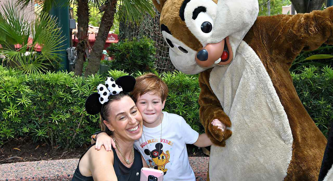 Image: A mother and son pose for a picture with Chip and Dale at Disney World