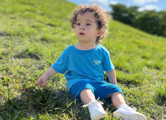 Image: A little boy sits in the grass