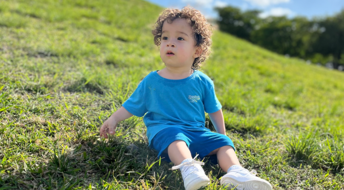 Image: A little boy sits in the grass