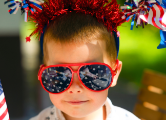 Firework Skewers: A Festive, Kid-Friendly Recipe Image: A child wearing 4th of July themed sunglasses and holding flag-themed props