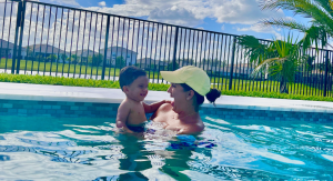 Image: A mother plays in a pool with her baby