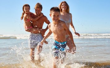 Top 7 South Florida Coast Vacations to Take This Summer Image: A family playing in the surf at the beach