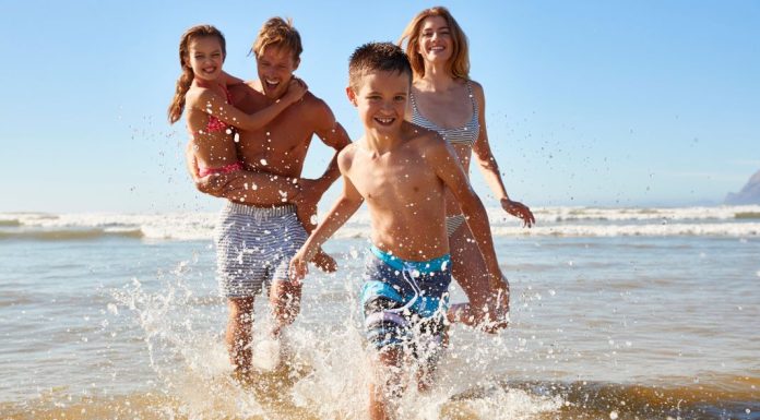 Top 7 South Florida Coast Vacations to Take This Summer Image: A family playing in the surf at the beach