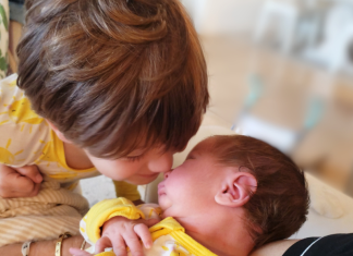 A Baby Over 40?! Here We Go Image: A little boy looks lovingly at his newborn brother